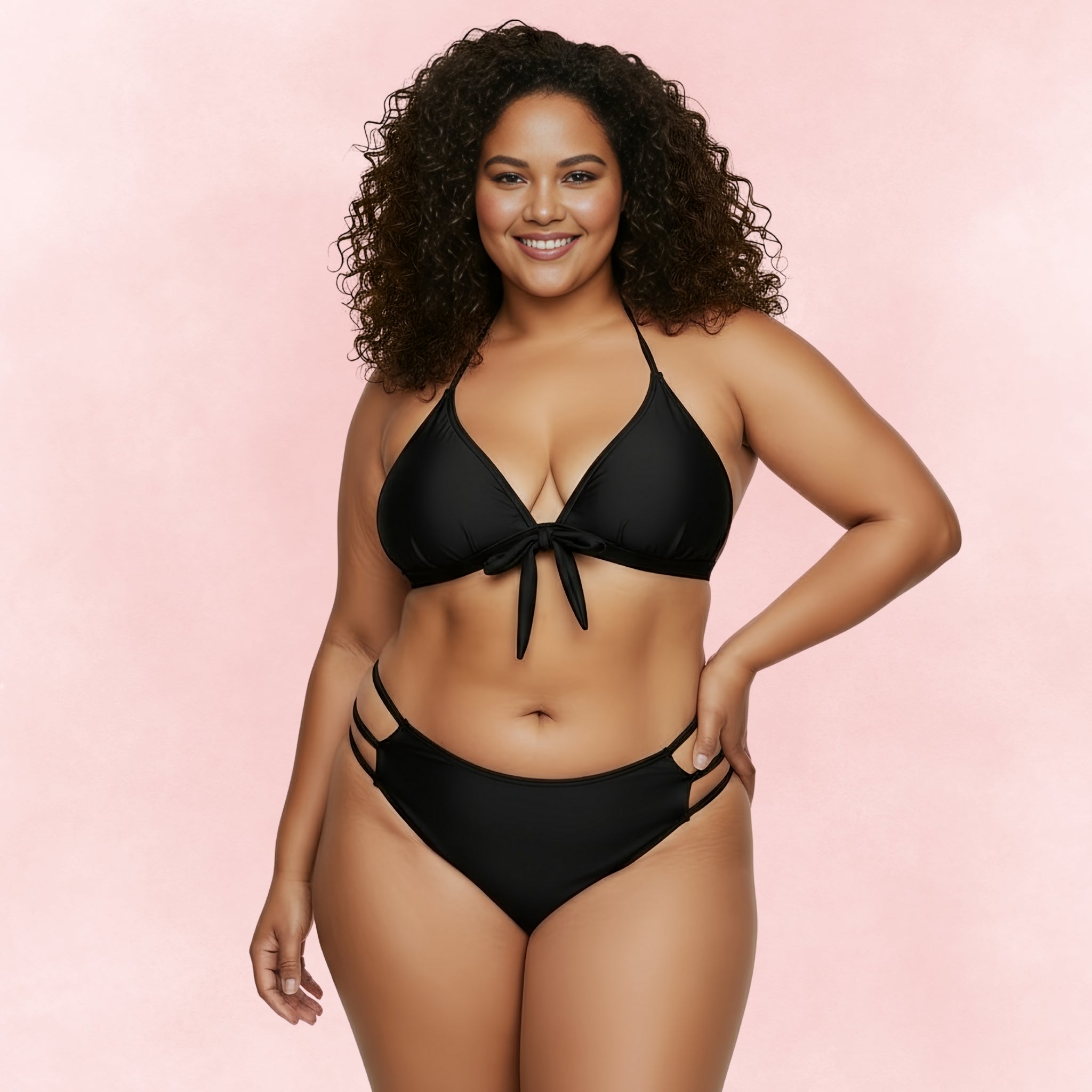 Confident plus size model in a black halter bikini with tie-front top and strappy bottoms, stylish swimwear for curves.