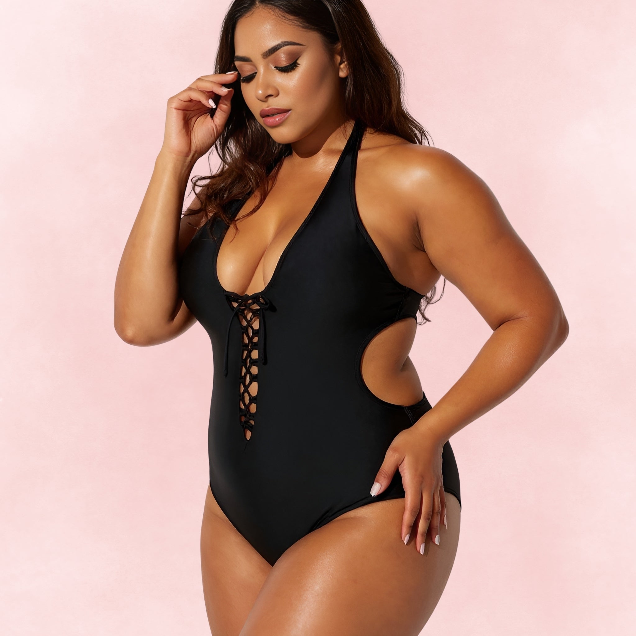 Front angle of plus size woman wearing black halter one-piece swimsuit with deep lace-up neckline and cutout sides