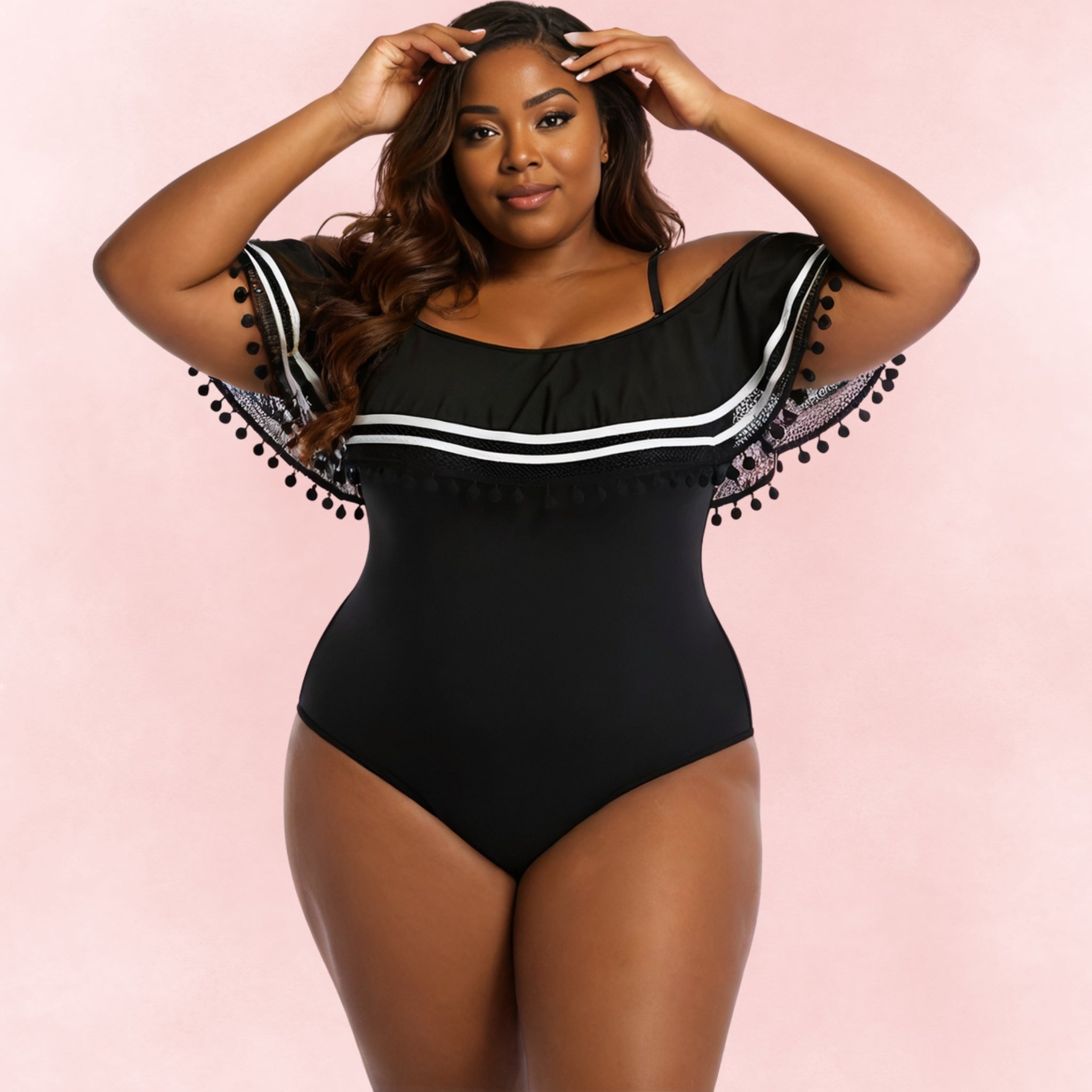 Front view of plus size woman wearing black one piece swimsuit with off-shoulder ruffle and pom pom lace trim.