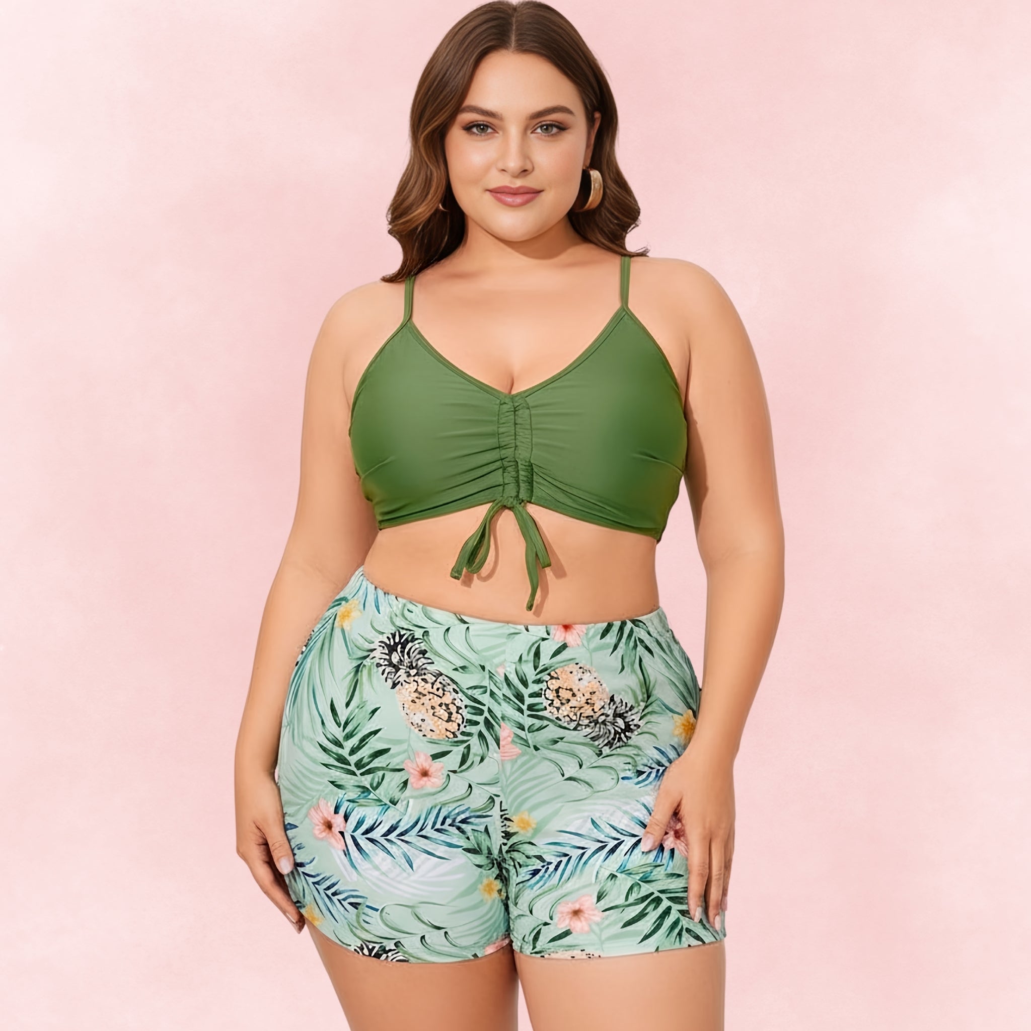 Plus-size green bikini top with ruched front tie, paired with high-waisted pineapple print swim shorts.