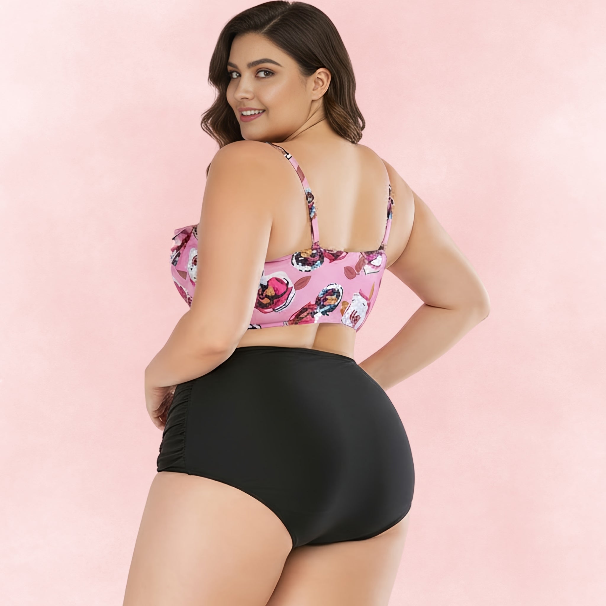 Back view of plus size woman wearing pink floral bikini top with ruffle details and black high waist bikini bottoms
