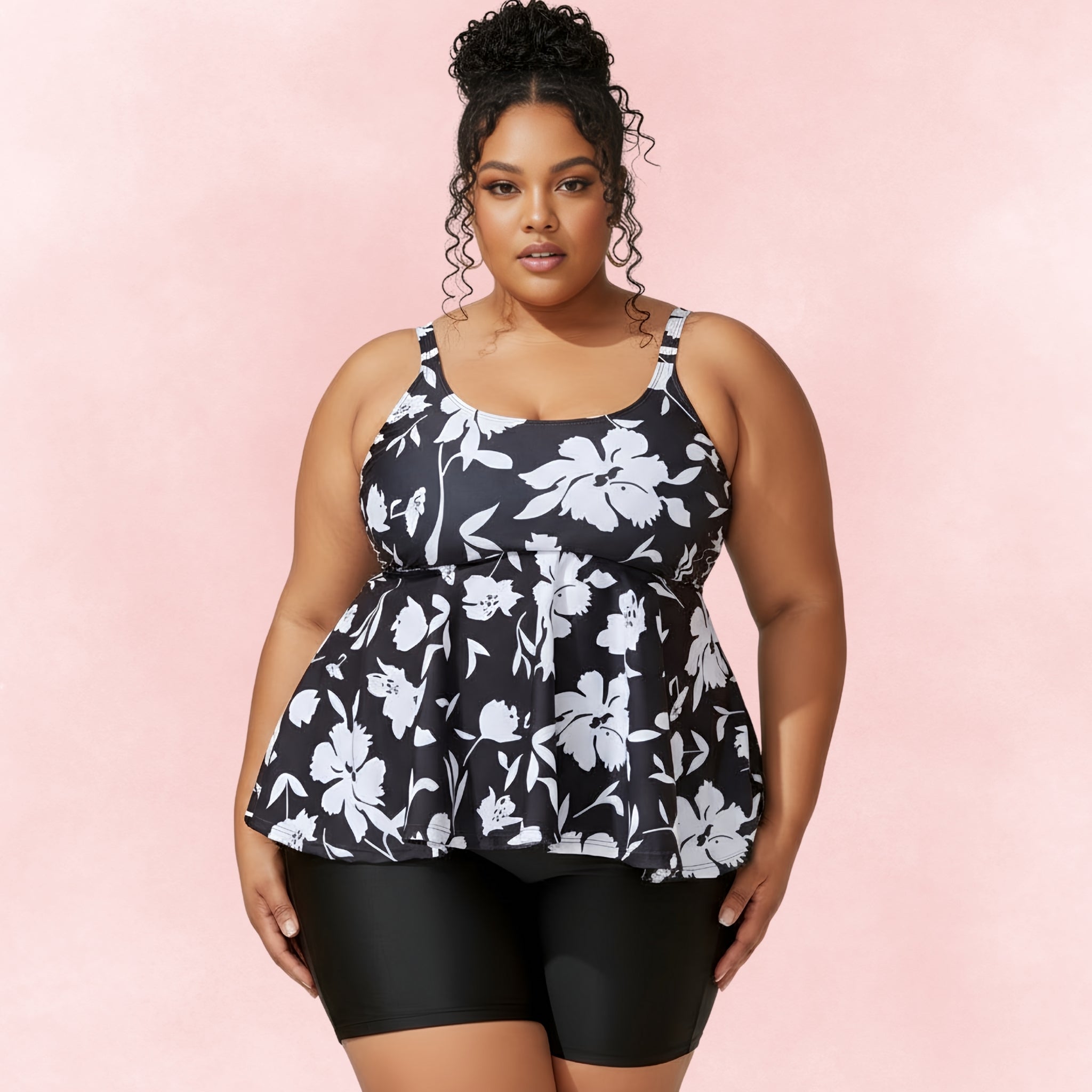 Front view of plus size model in black and white floral tankini set with slimming swim shorts