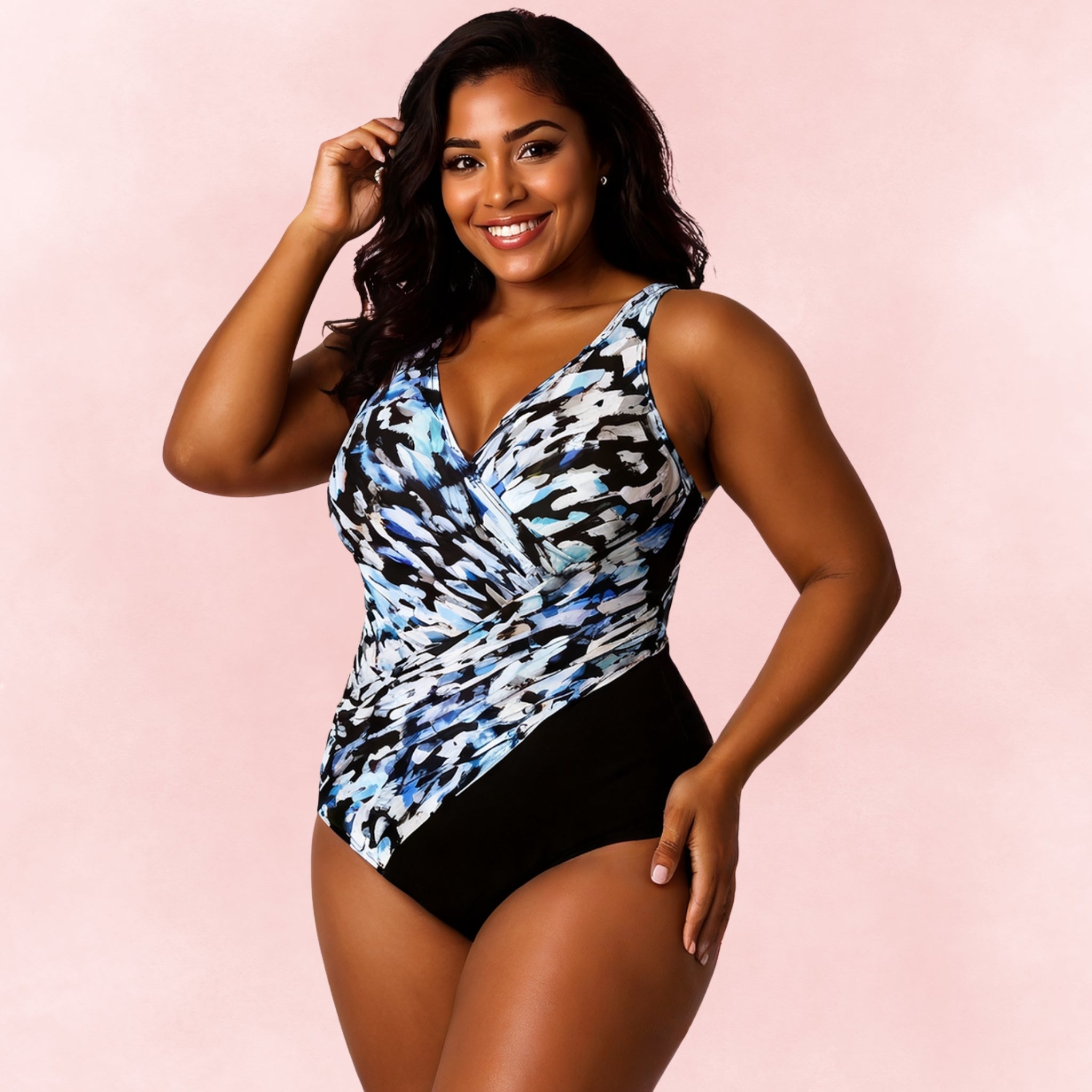 Plus size one-piece swimsuit with blue abstract print top and solid black bottom, wrap front design
