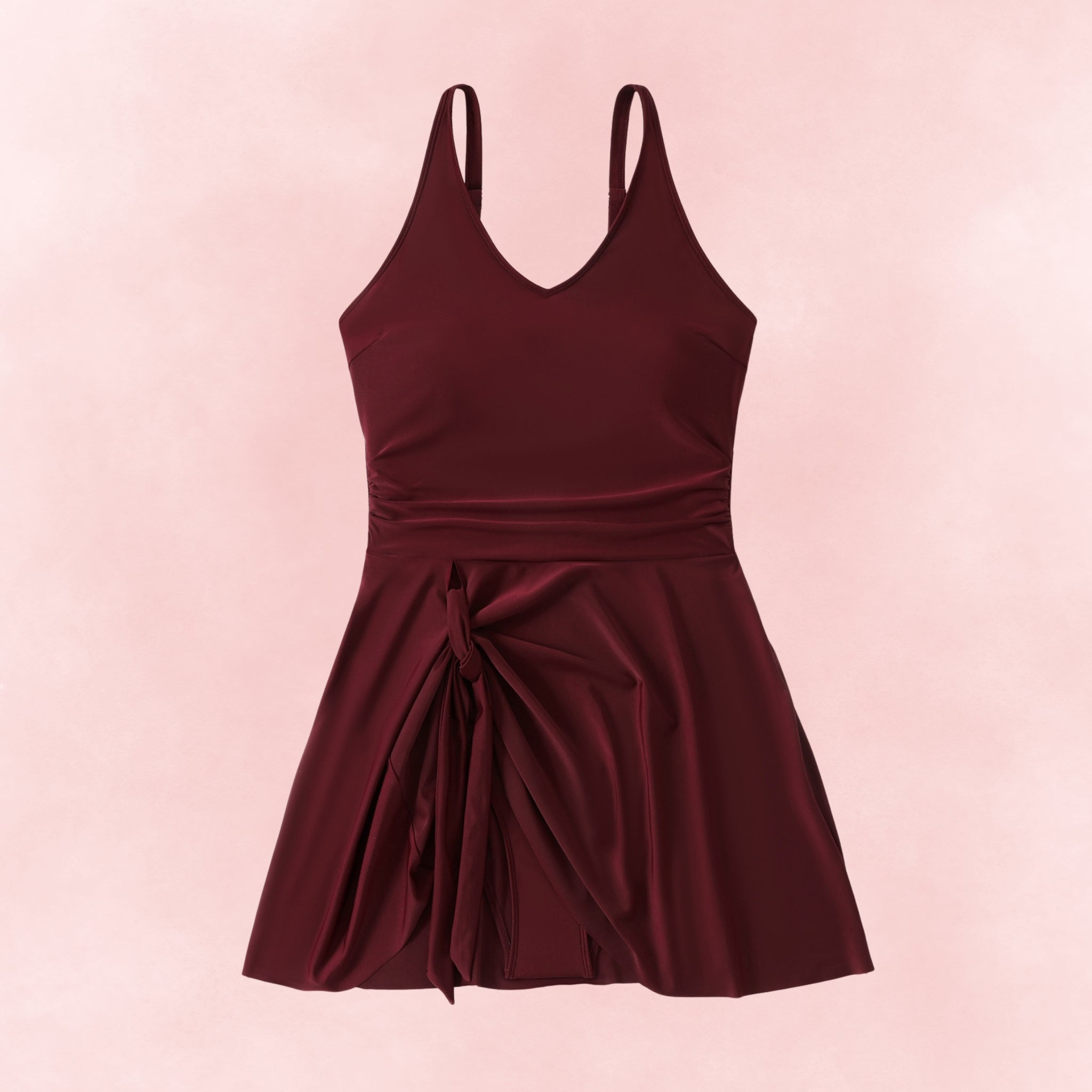Flat lay of plus size burgundy swimdress with v-neckline and tied skirt overlay