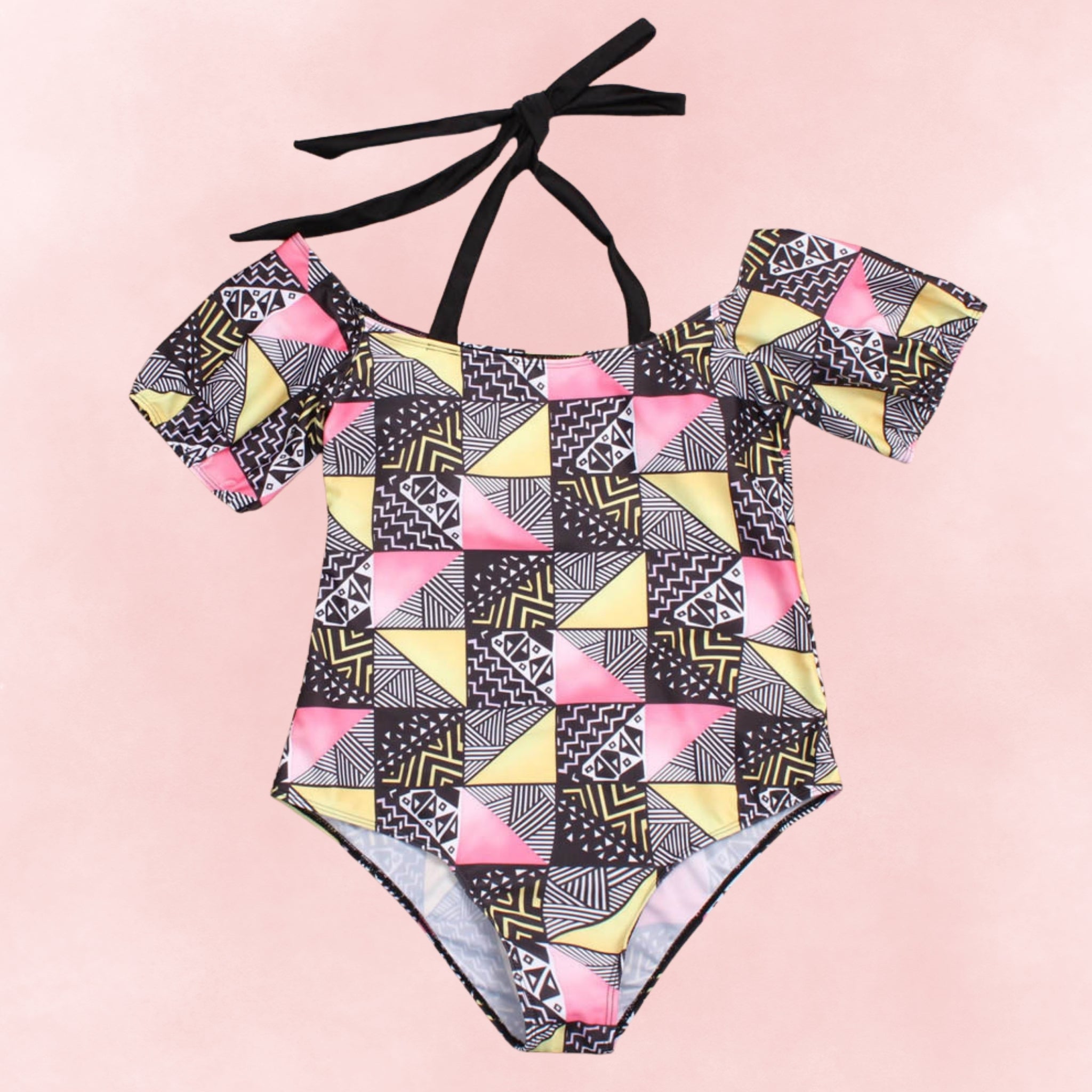 Flat lay of plus size one-piece swimsuit with multicolor tribal geometric print and off-shoulder straps