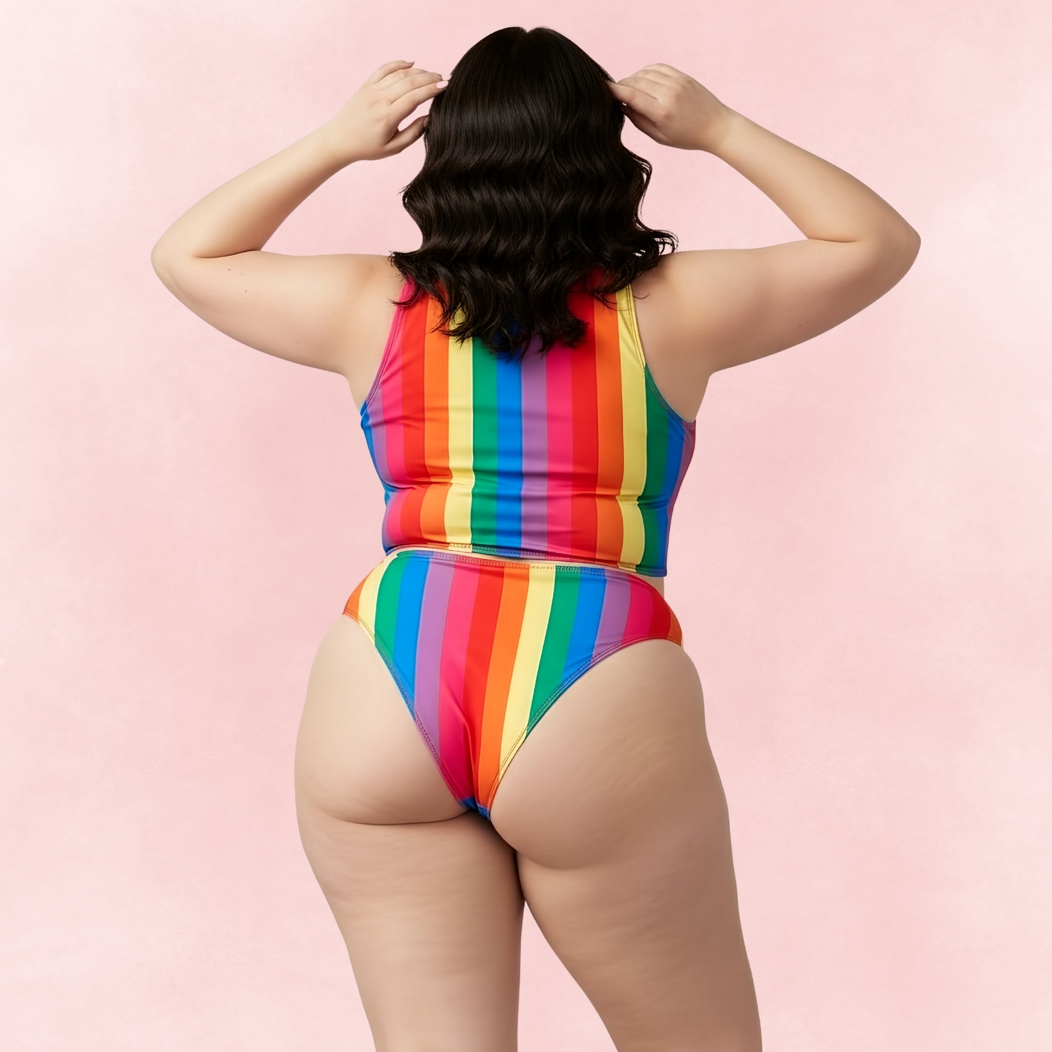 Back view of plus size woman in rainbow stripe bikini set with high waist bottoms and racerback crop top